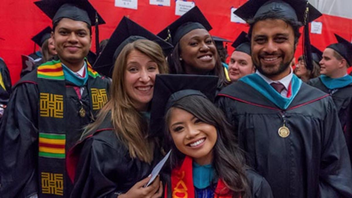 DU graduates posing together at commencement